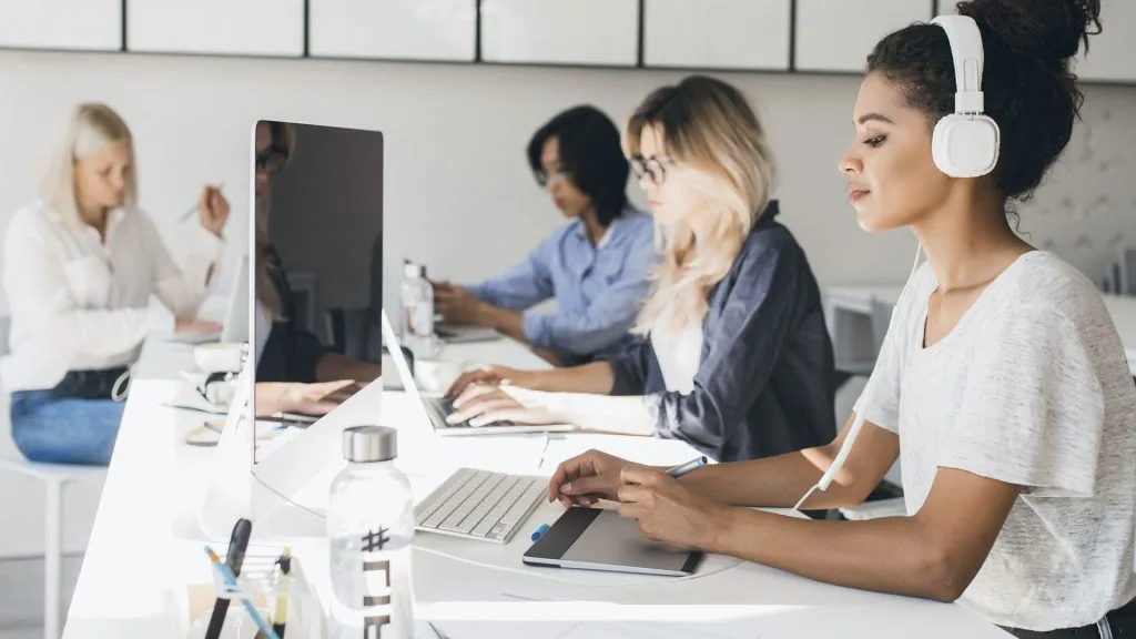 Equipe trabalhando em computadores num escritório claro